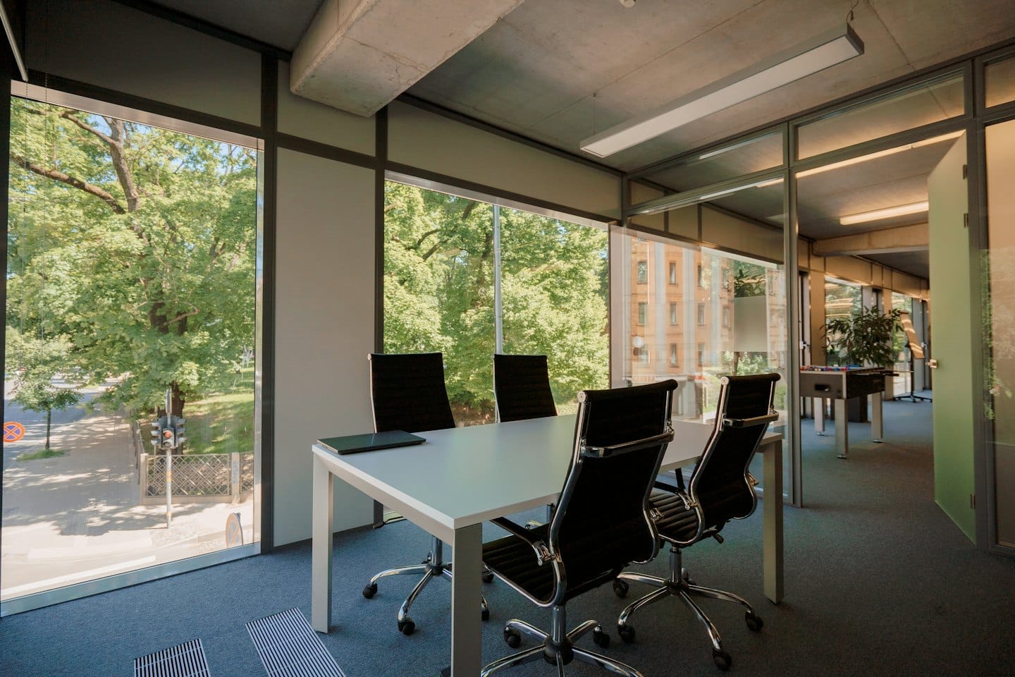 Sala riunioni moderna con tavolo grande e pareti in vetro.